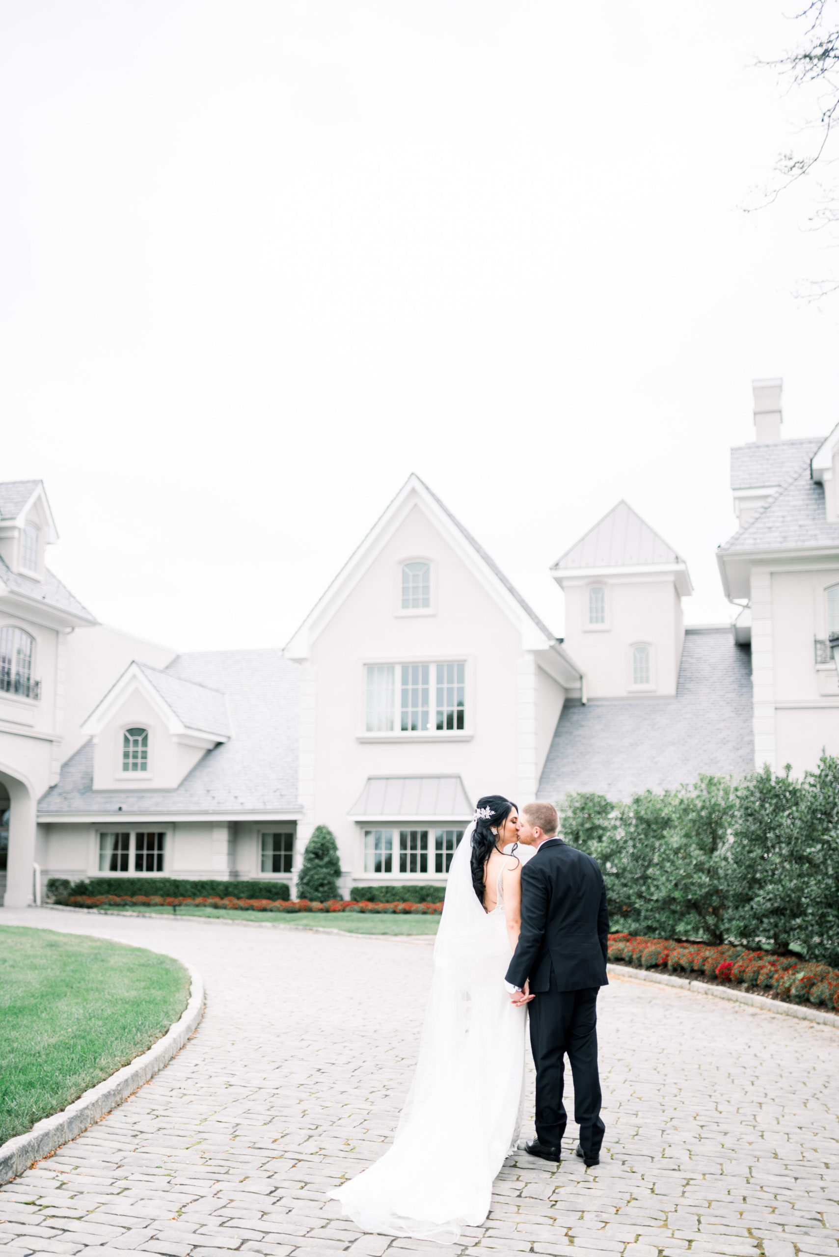 bride and groom kiss outside Park Chateau Estate 