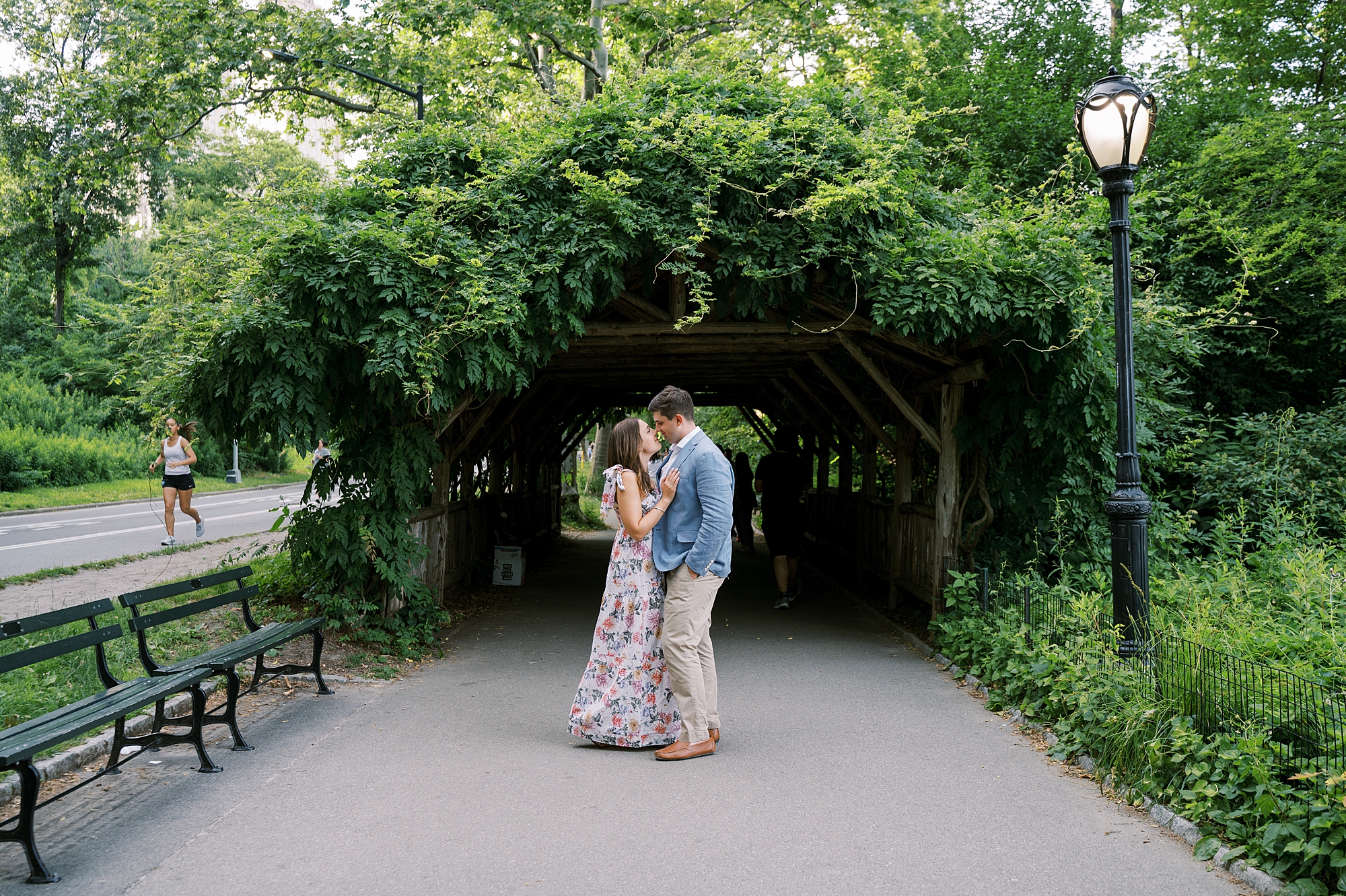 bride and groom hug under arbor in Central Park