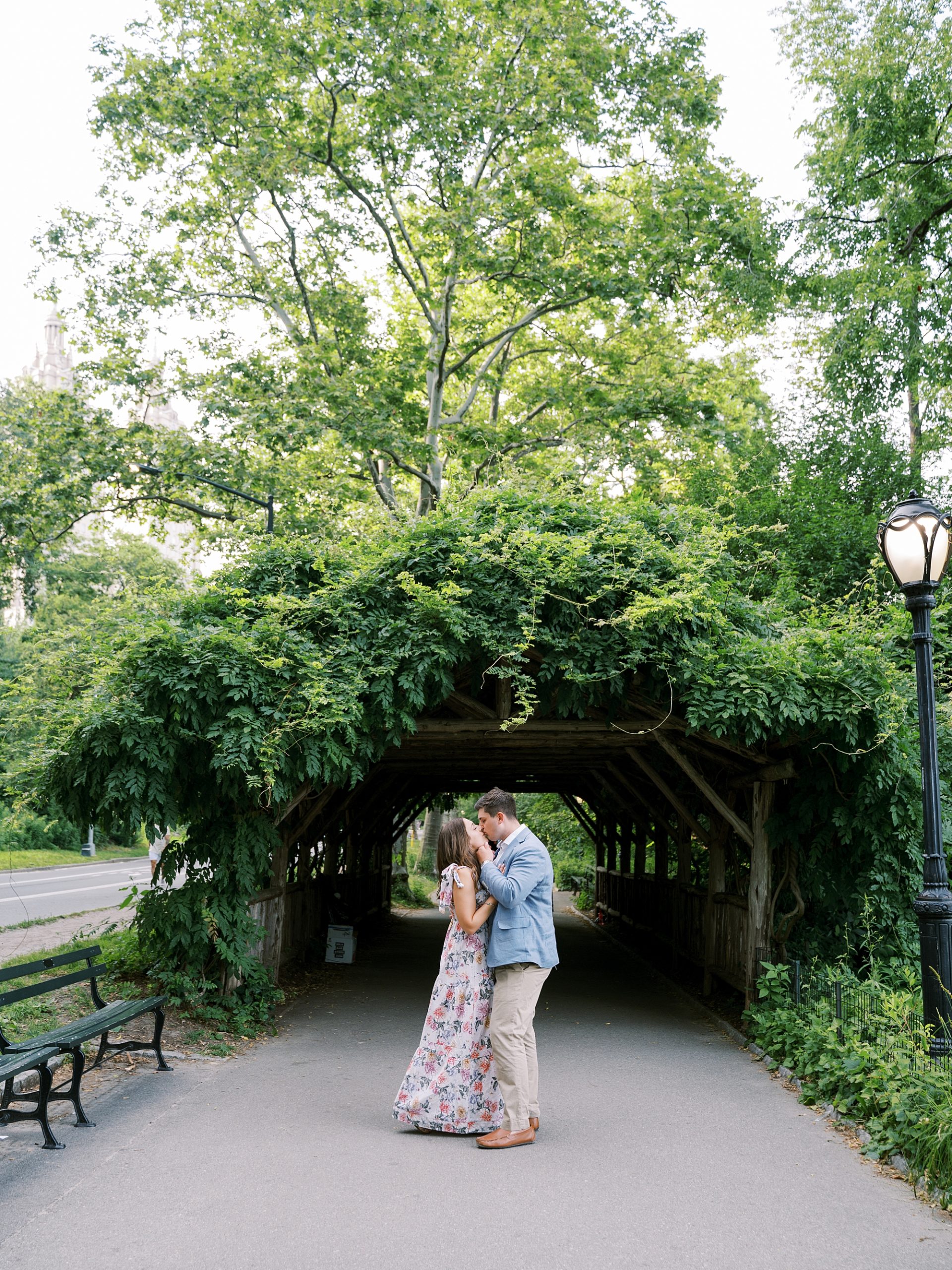 bride and groom pose under greenery covered arbor at Central Park