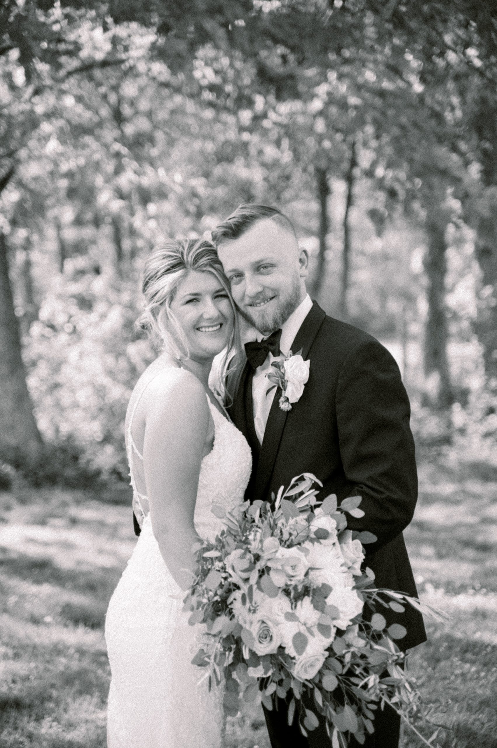 black and white portrait of bride and groom hugging at The Grove at Centerton