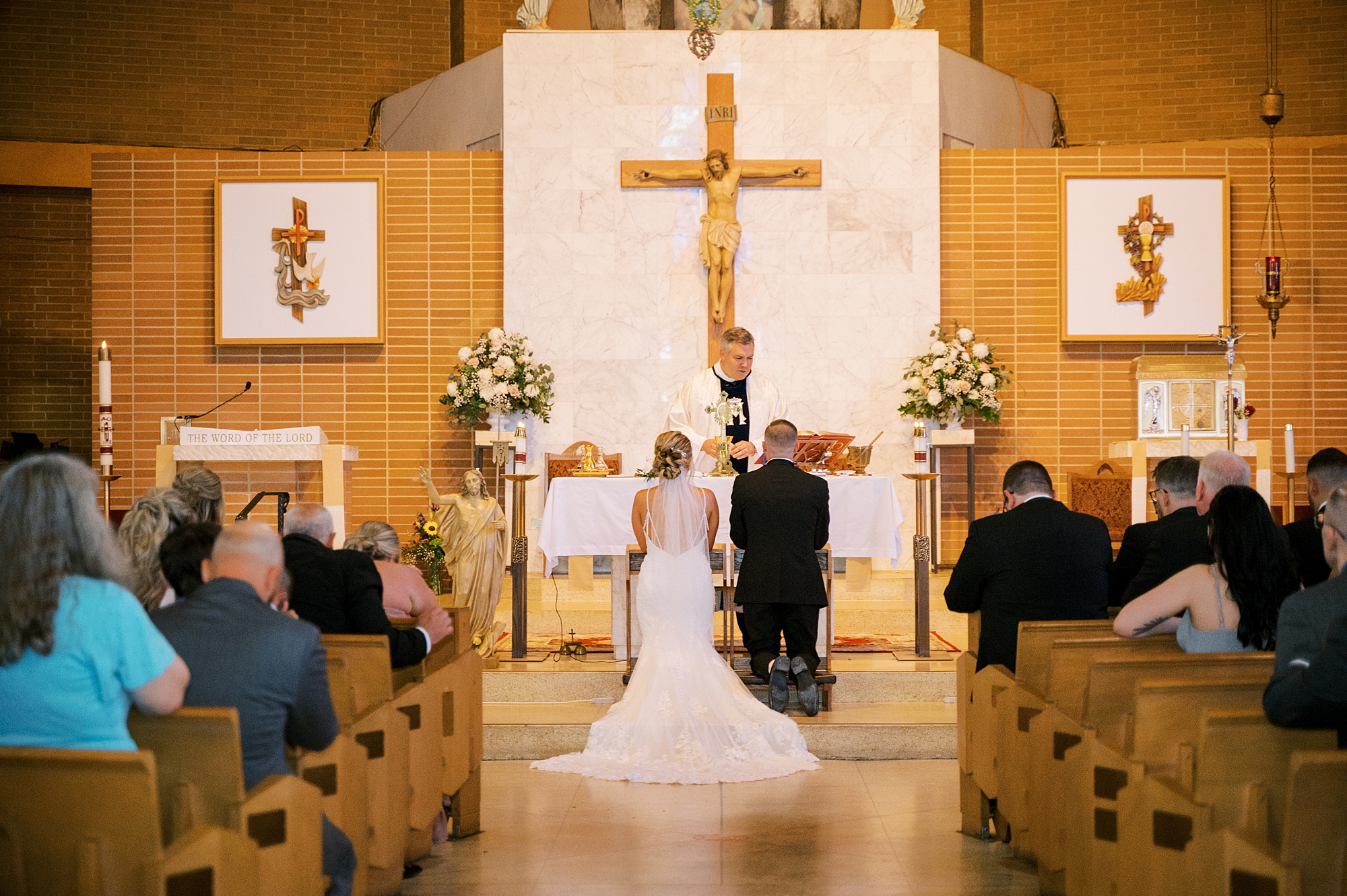 bride and groom kneel during traditional church wedding ceremony in New Jersey
