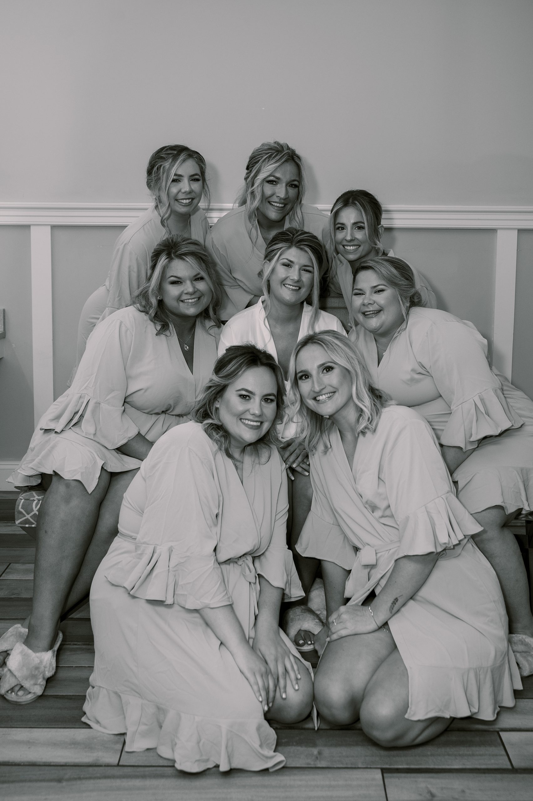 bride poses with bridesmaids in matching robes before NJ wedding