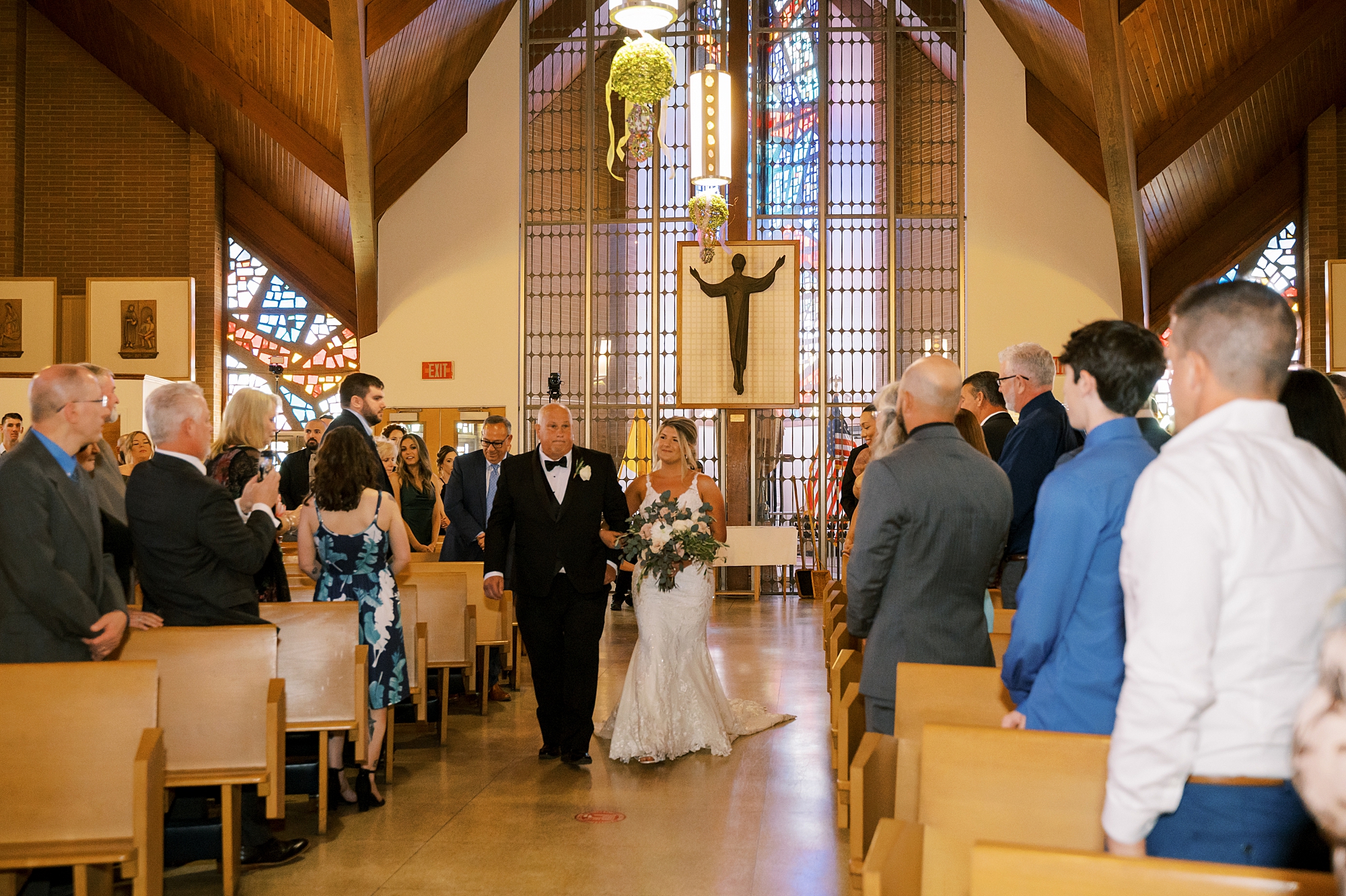 bride walks down aisle with father during traditional church wedding ceremony in New Jersey
