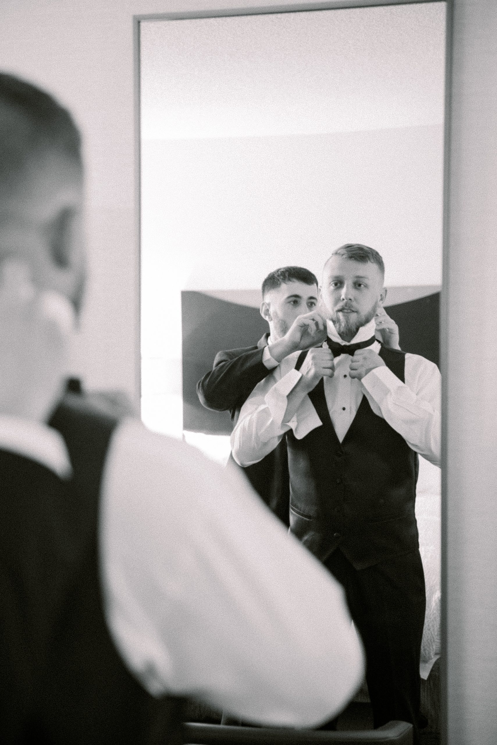 groom adjusts tie before NJ wedding day at The Grove at Centerton