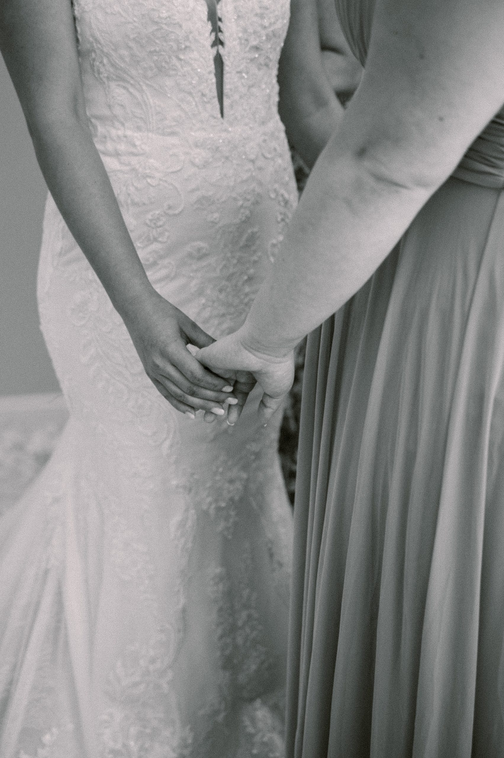 bride and mother hold hands during wedding prep 