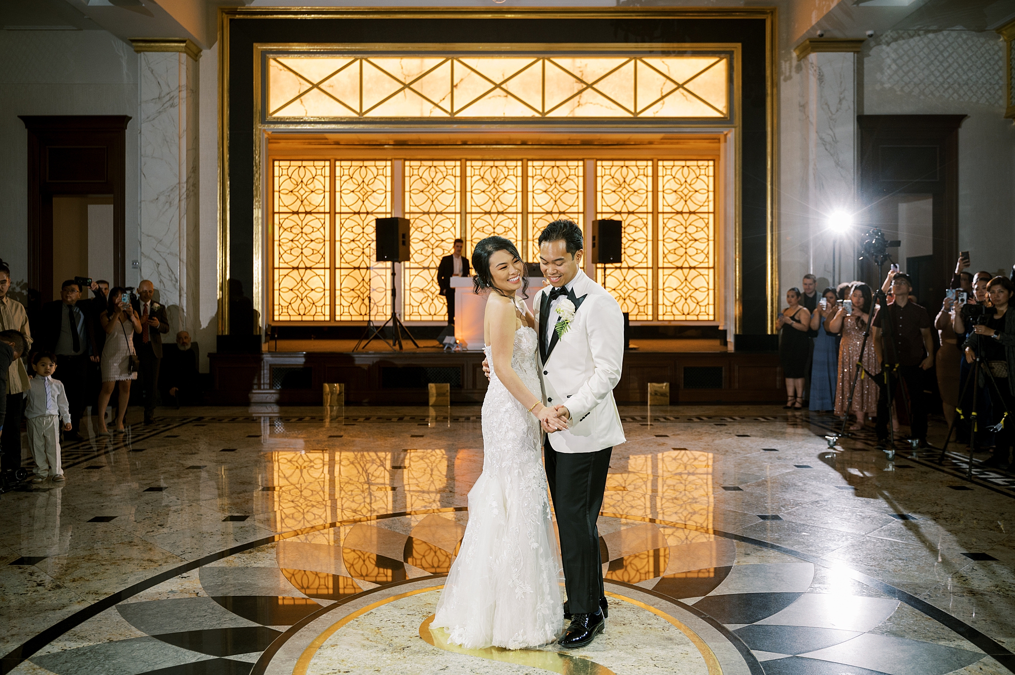 newlyweds have first dance during wedding reception in ballroom