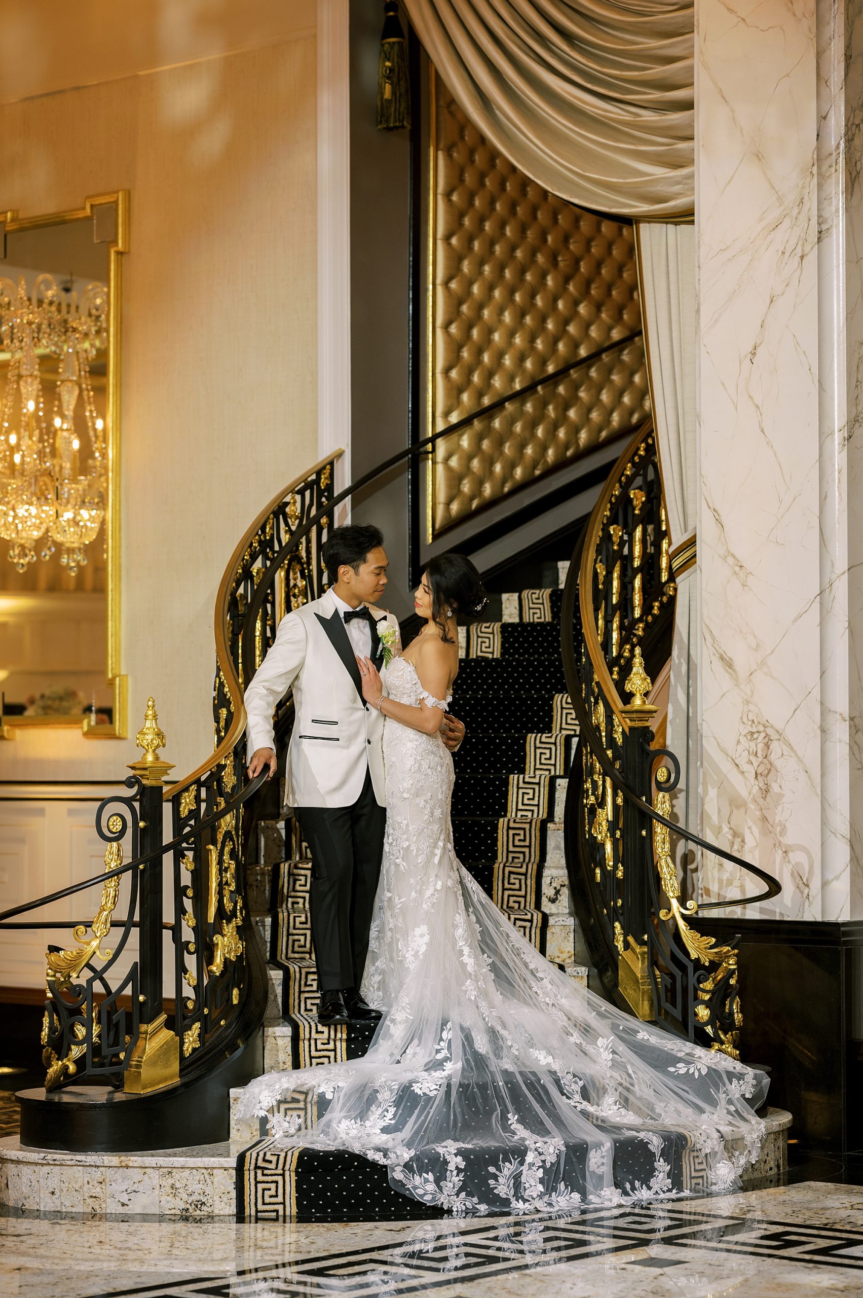 bride and groom stand on black and gold staircase at Shadowbrook at Shrewsbury