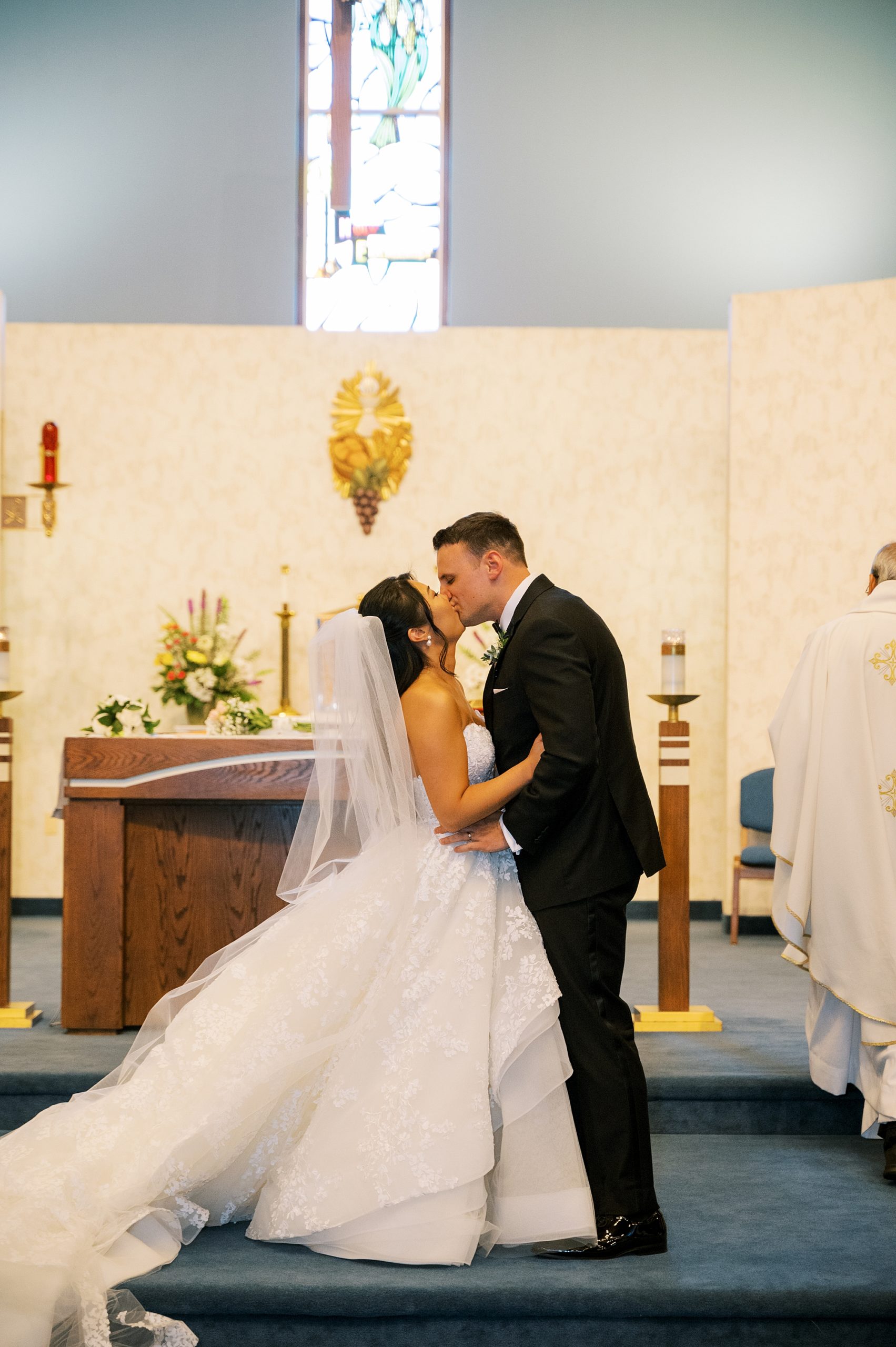 bride and groom kiss during church wedding ceremony 