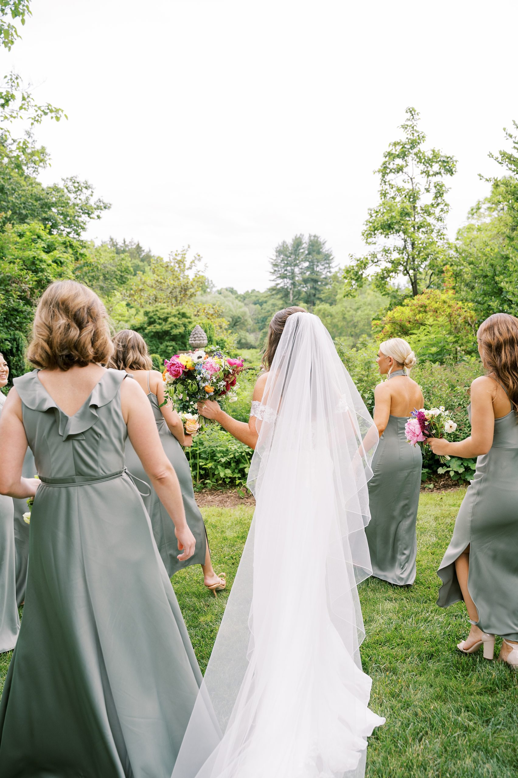 bride walks with bridesmaids at Willowwood Arboretum