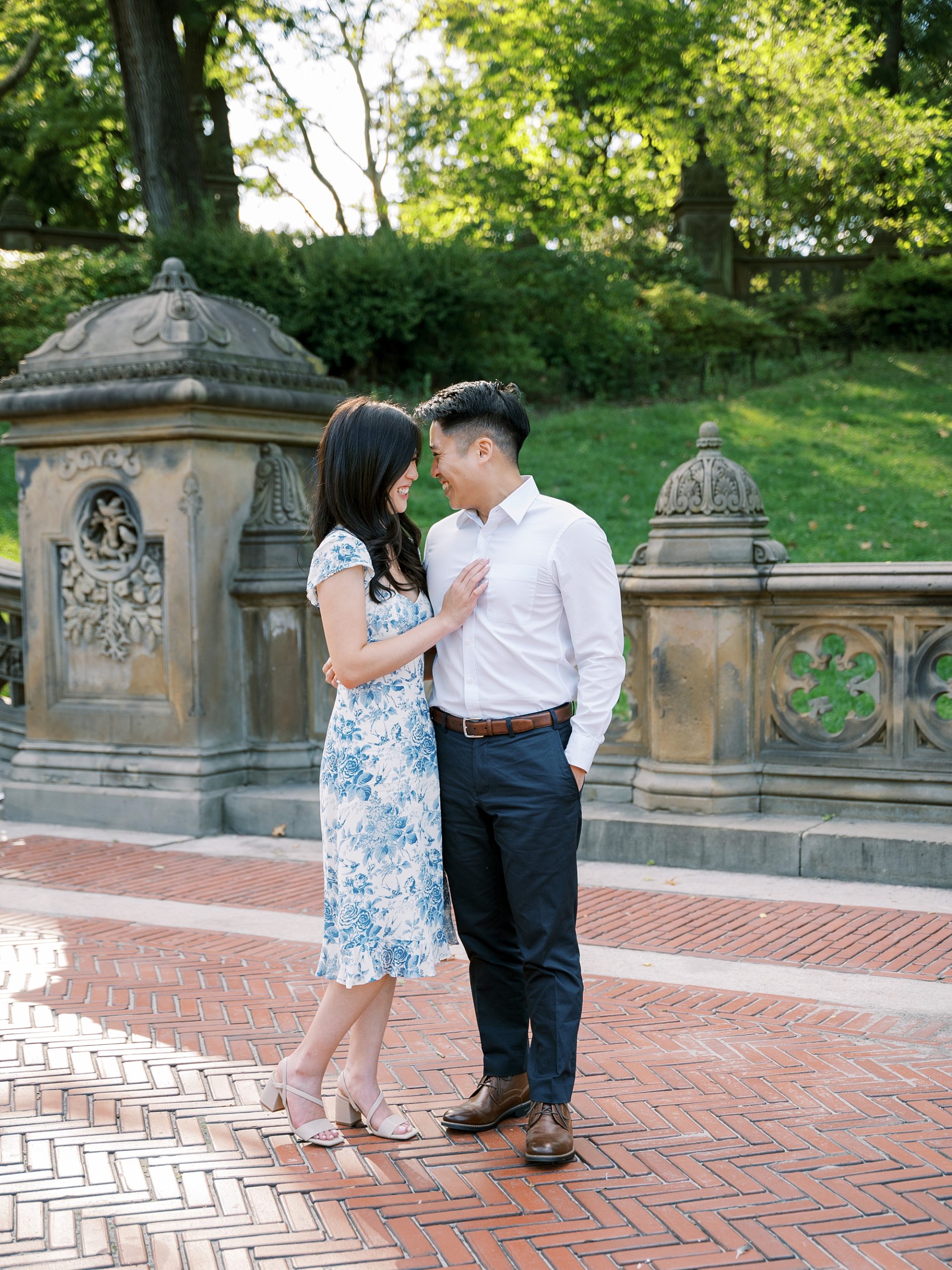 woman leans into fiancee's chest standing in Central Park