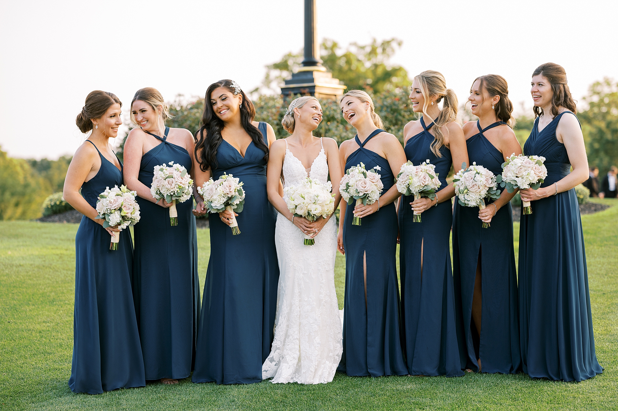 bride laughs with bridesmaids in navy gowns