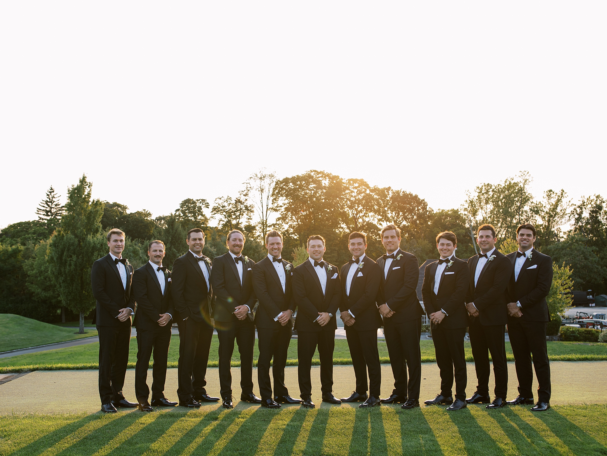 groom stands with groomsmen in classic suits at Trump National Golf Club Westchester