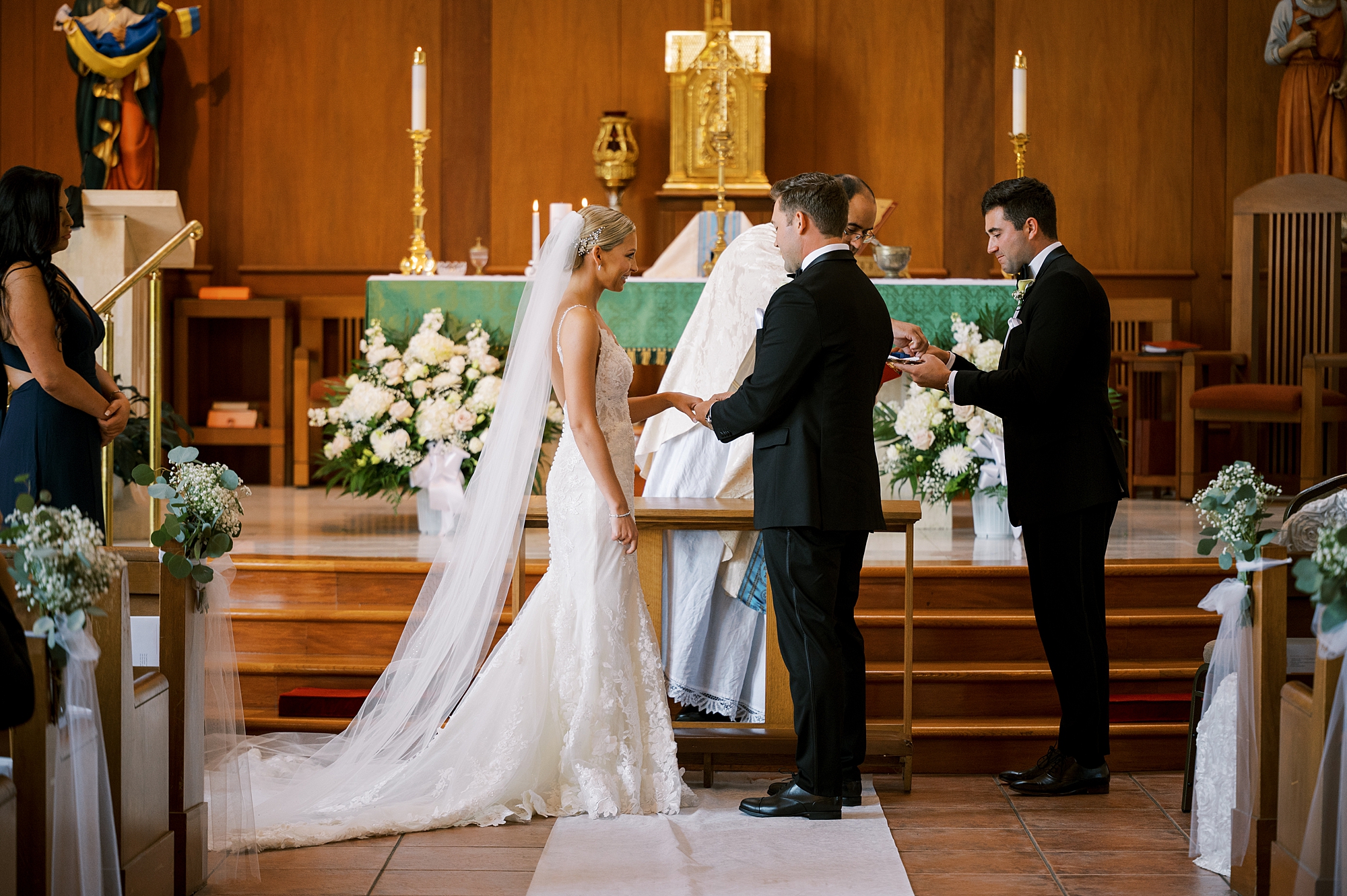 newlyweds exchange rings during traditional Catholic Church wedding at St. Augustine Catholic Church