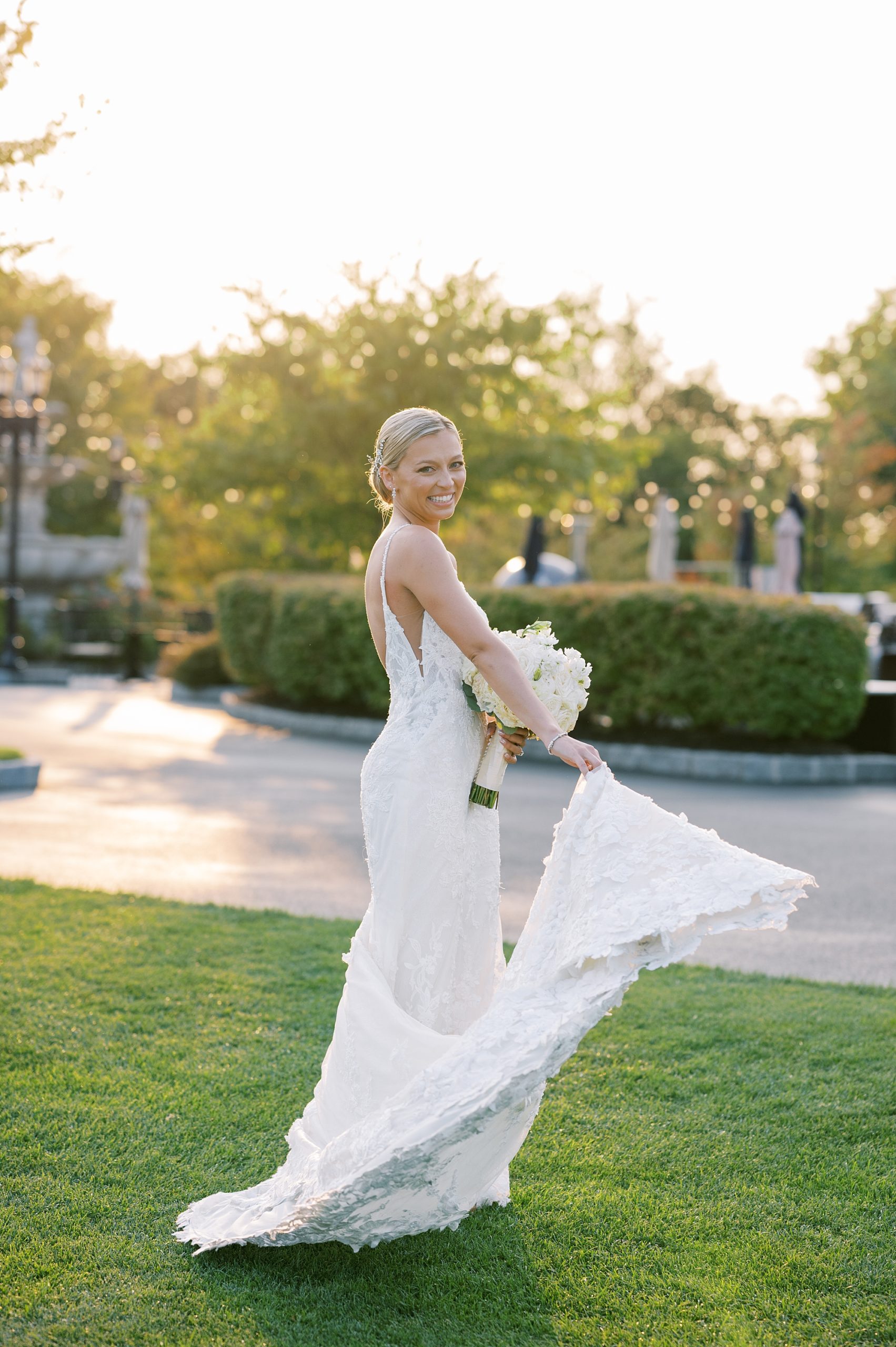 bride twirls wedding dress by water at Trump National Golf Club Westchester
