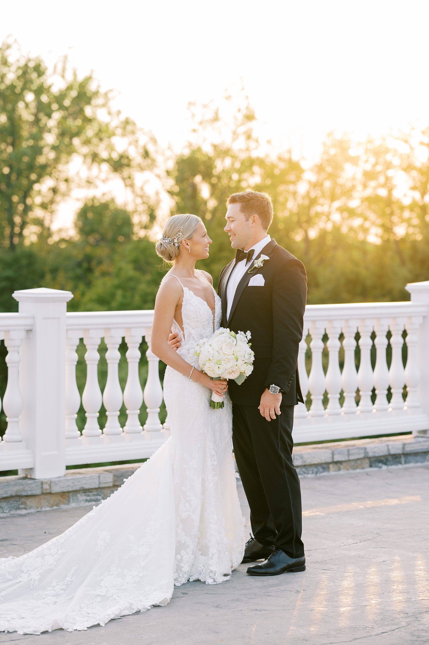 bride and groom smile at sunset on patio at Trump National Golf Club Westchester