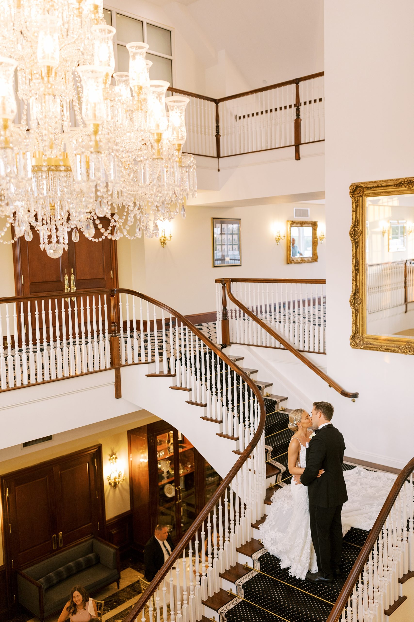 bride and groom pose on staircase inside Trump National Golf Club Westchester