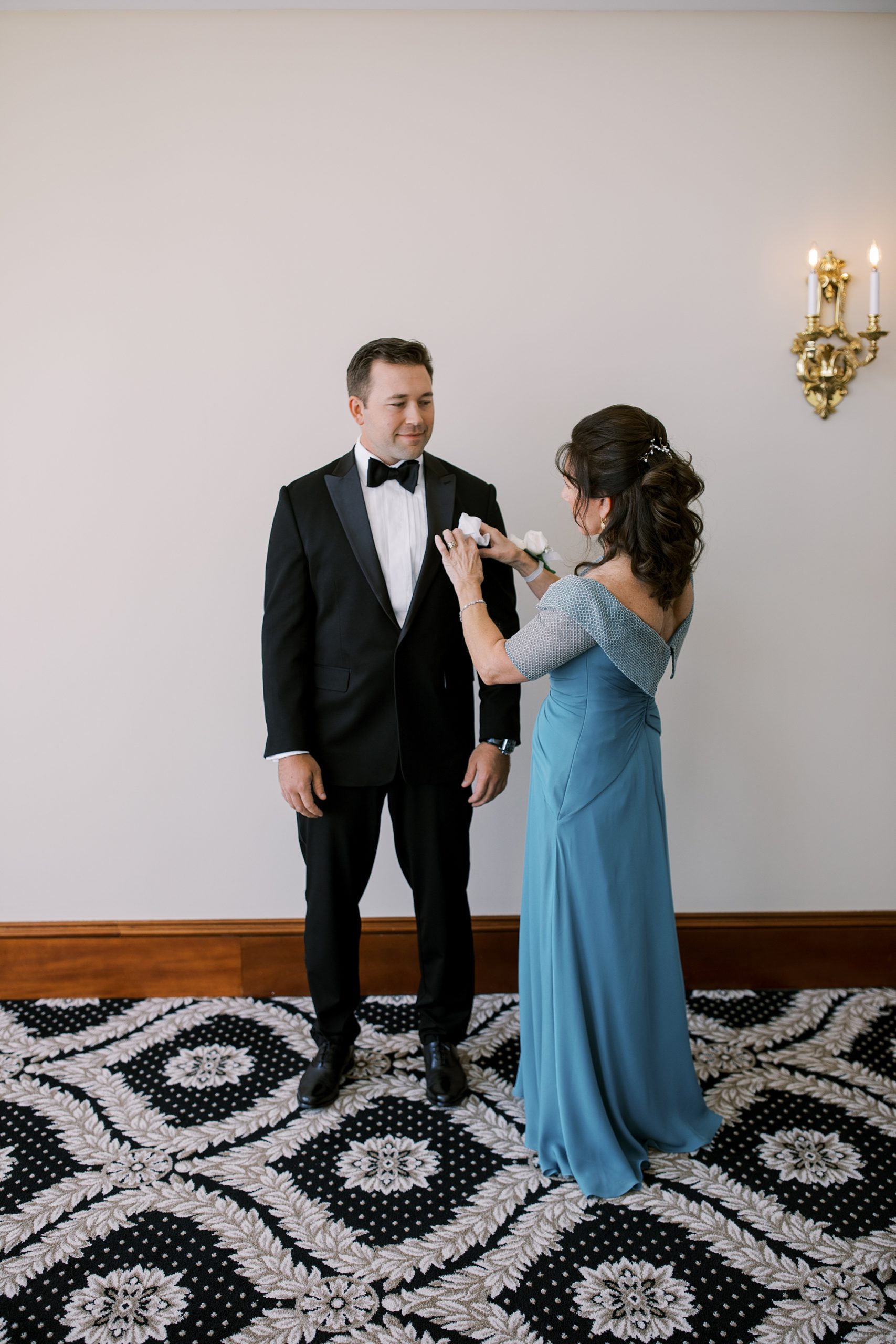 mother pins on boutonnière for groom before Trump National Golf Club Westchester wedding