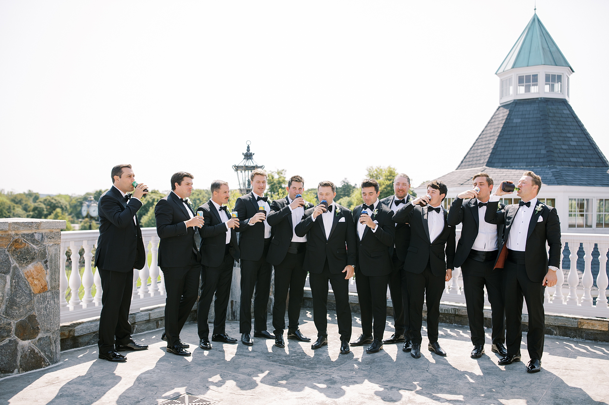 groom and groomsmen toast beer during portraits on patio at Trump National Golf Club Westchester