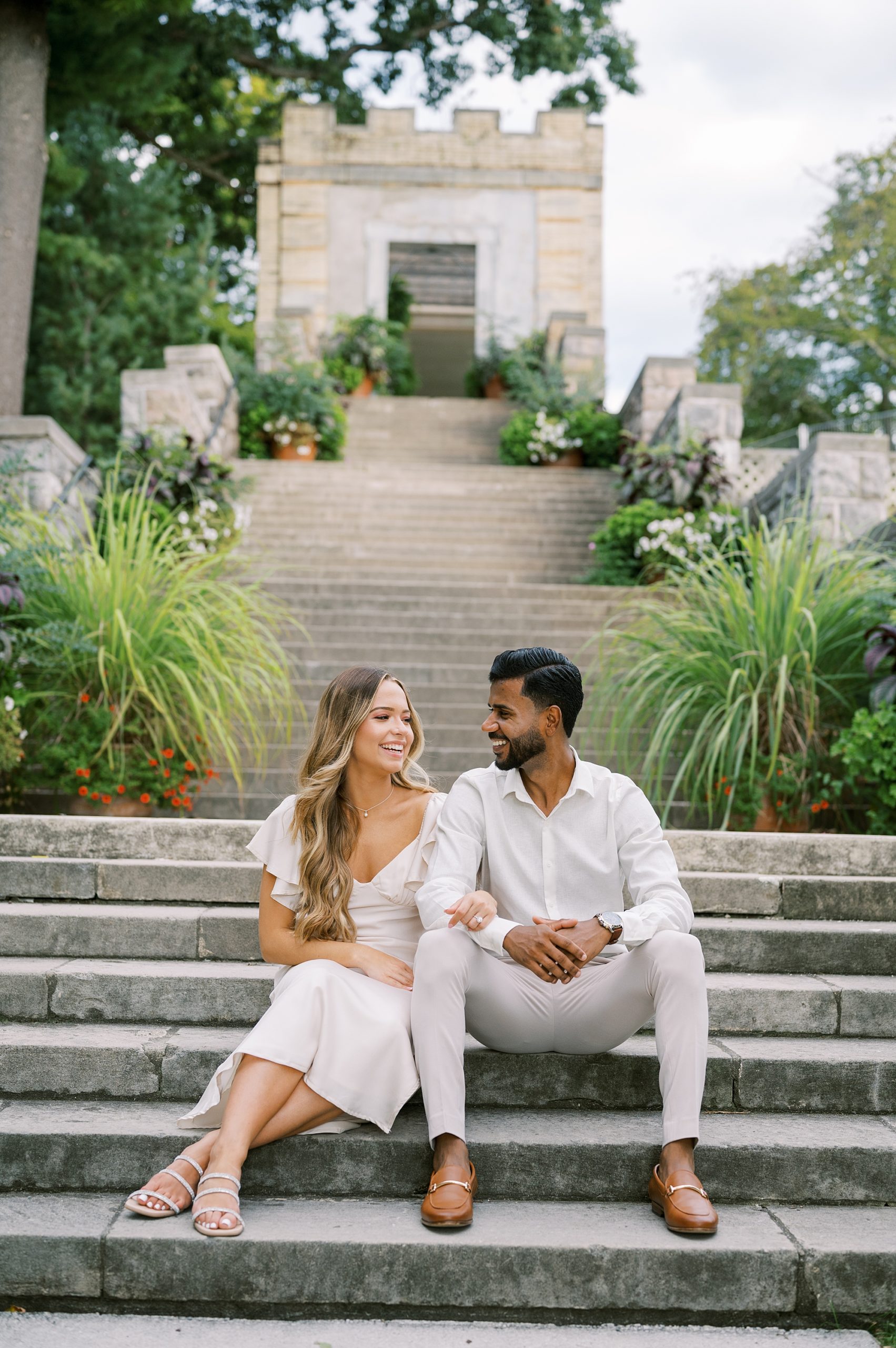 man and woman in white outfits sit on stone steps at Untemyer Gardens Conservancy