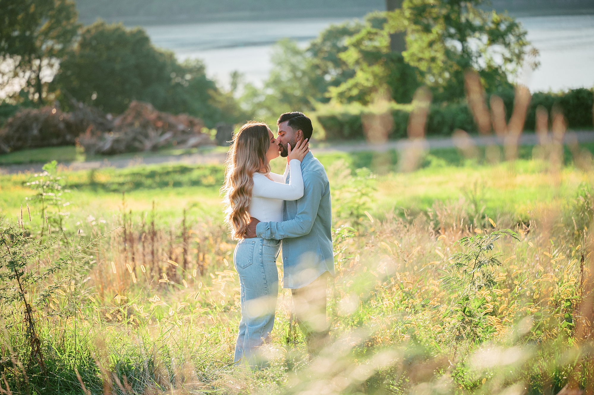 engaged couple kisses in field in Yonkers NY