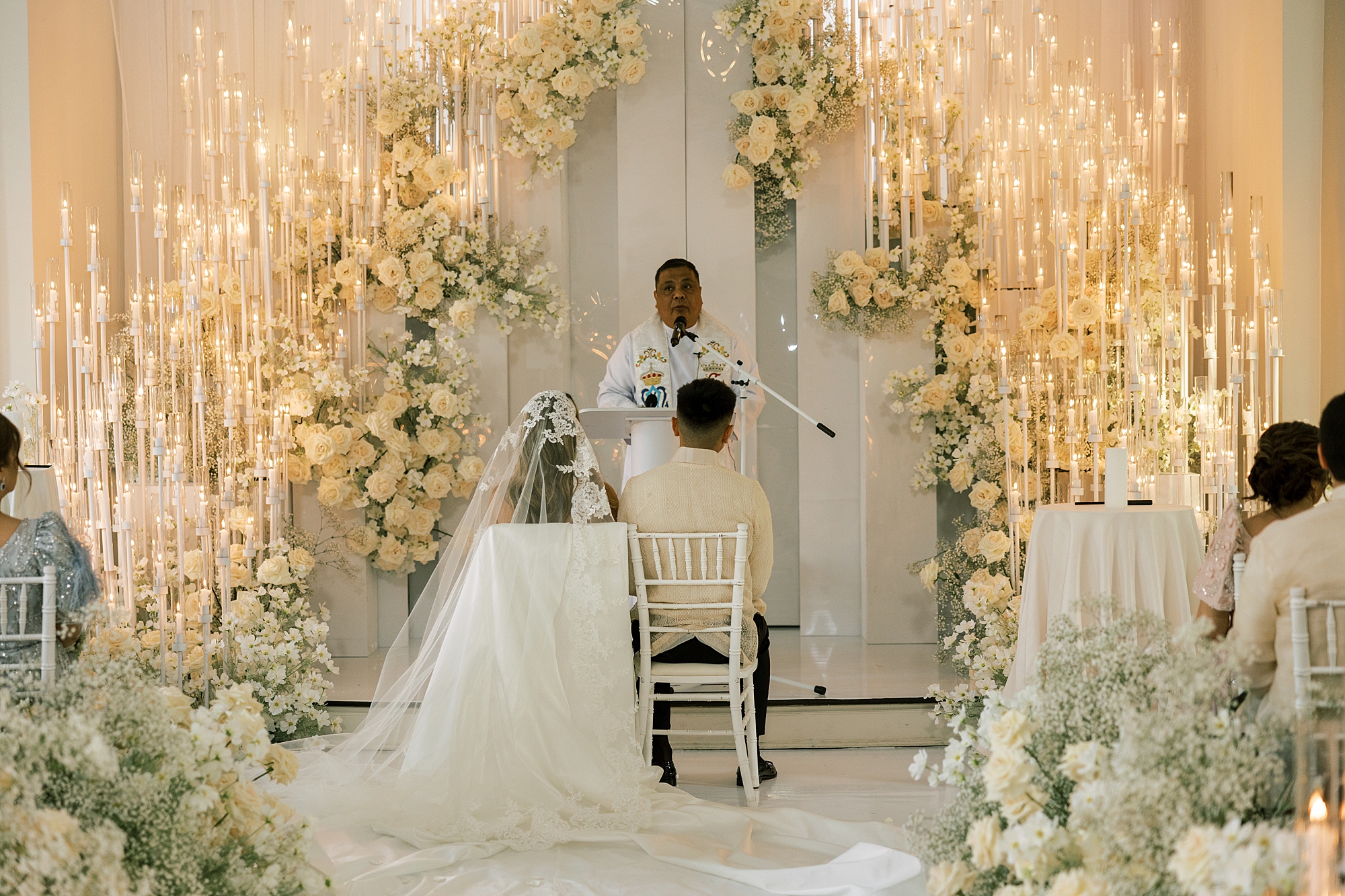 officiant speaks to bride and groom sitting during ceremony inside Park Chateau Estate chapel