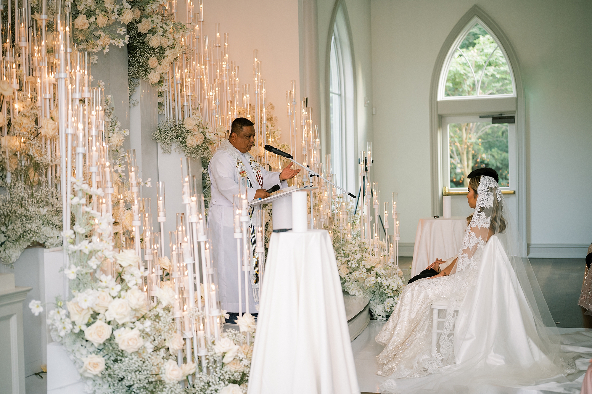 officiant speaks to bride and groom during candle lit ceremony in chapel at Park Chateau