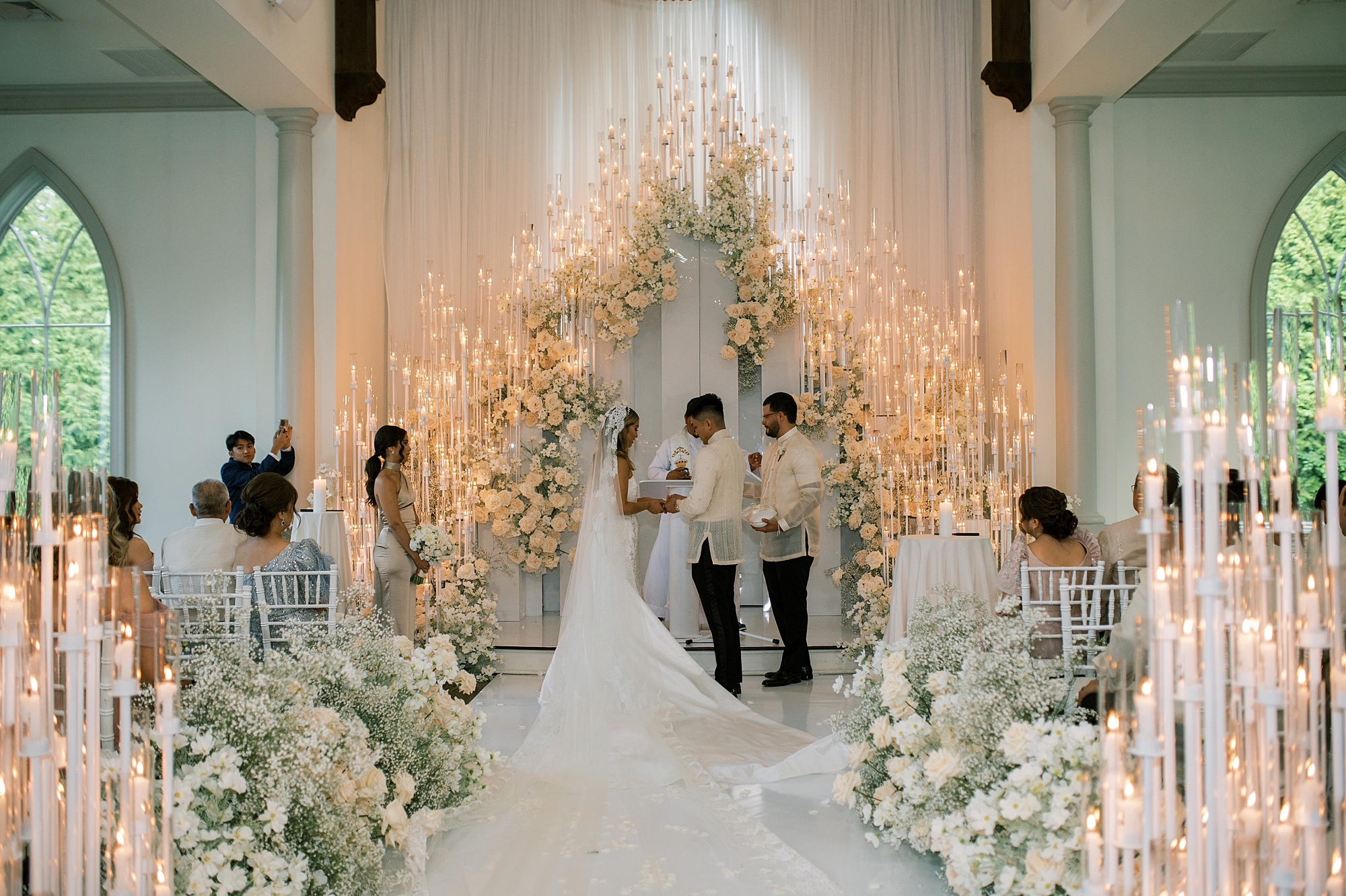 newlyweds read vows in front of dramatic floral and candle display inside Park Chateau chaepl