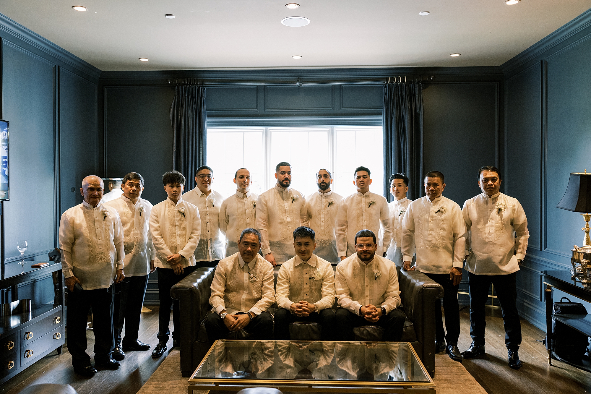 groom and groomsmen sit inside groom's suite at Park Chateau