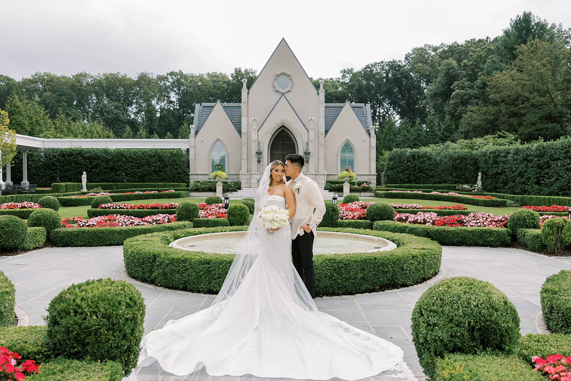 newlyweds hug in gardens at Park Chateau Estate