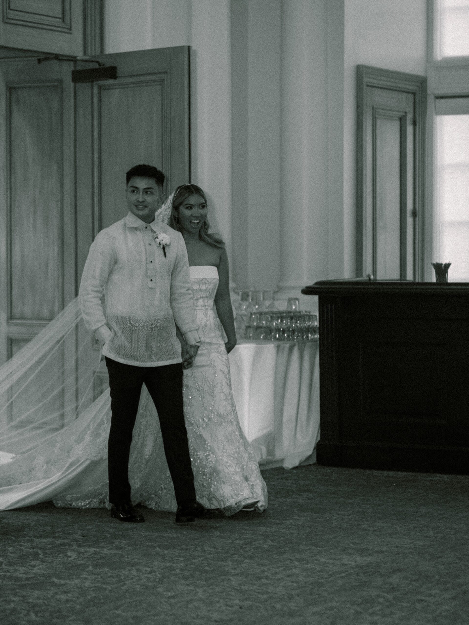 bride and groom smile walking into reception space at Park Chateau Estate