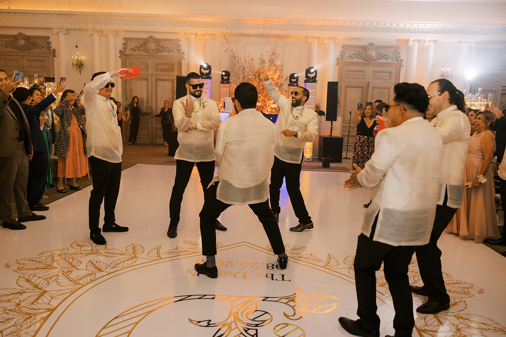 groomsmen in linen shirts dance in ballroom at Park Chateau Estate