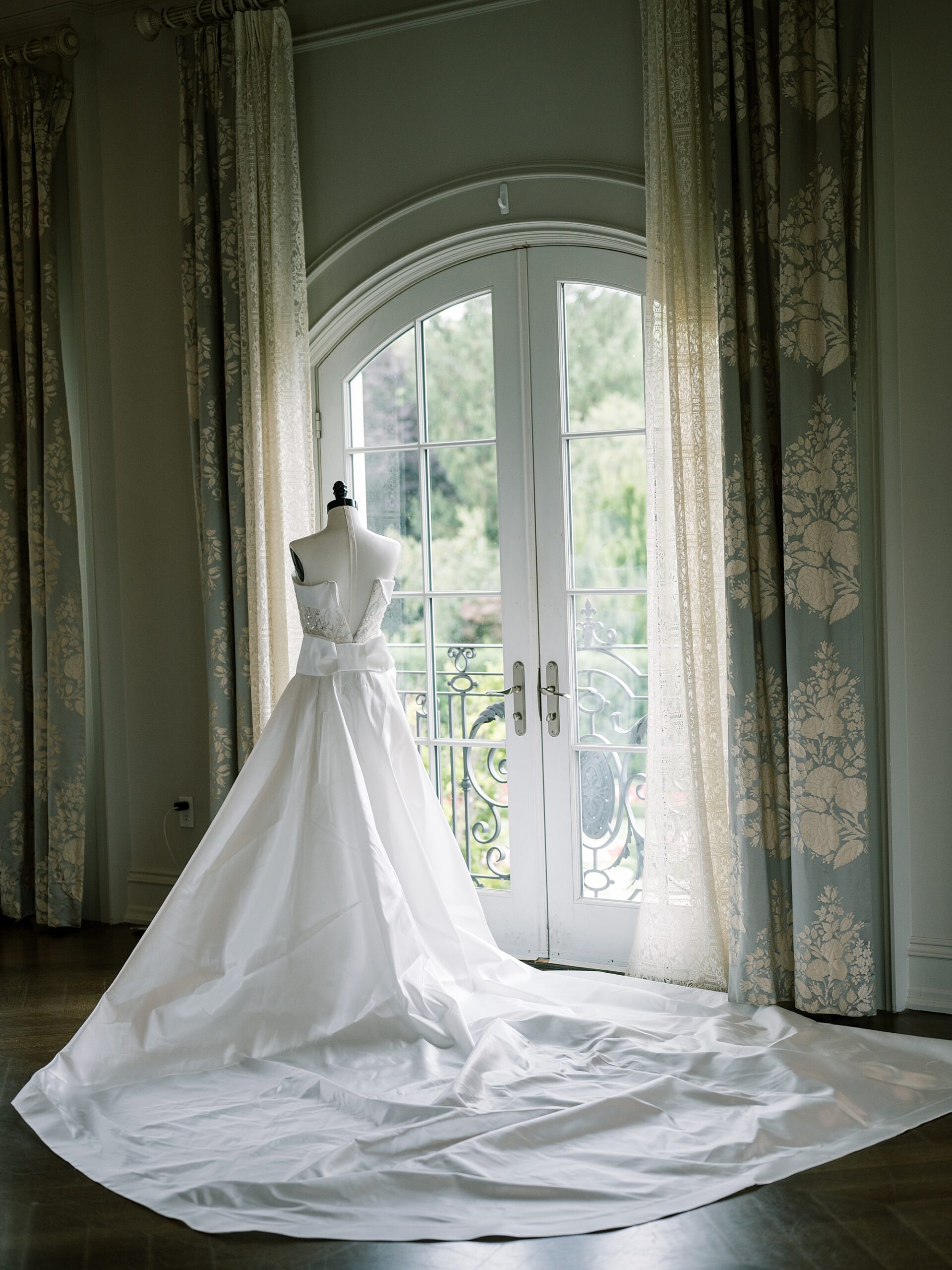 wedding dress sits on mannequin by window inside bridal suite at Park Chateau Estate