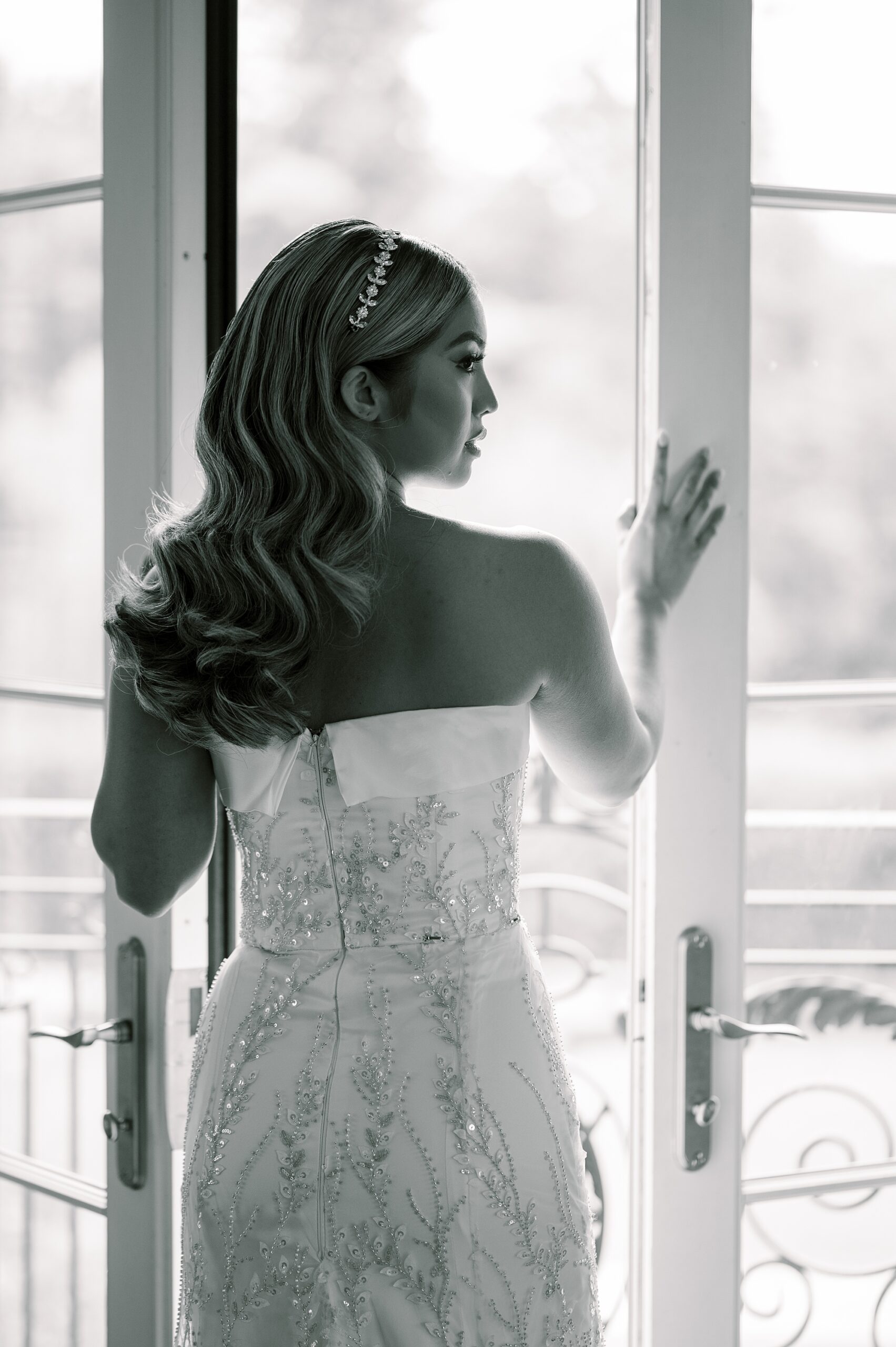 bride stands between glass doors at bridal suite at Park Chateau Estate