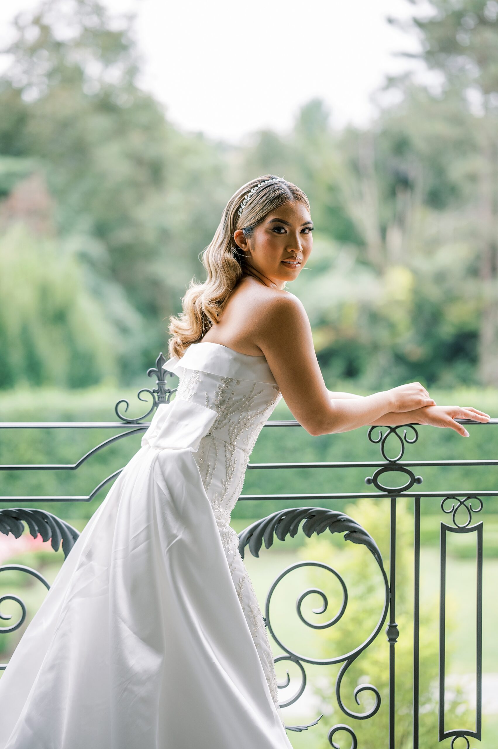 bride leans on railing of balcony at Park Chateau Estate