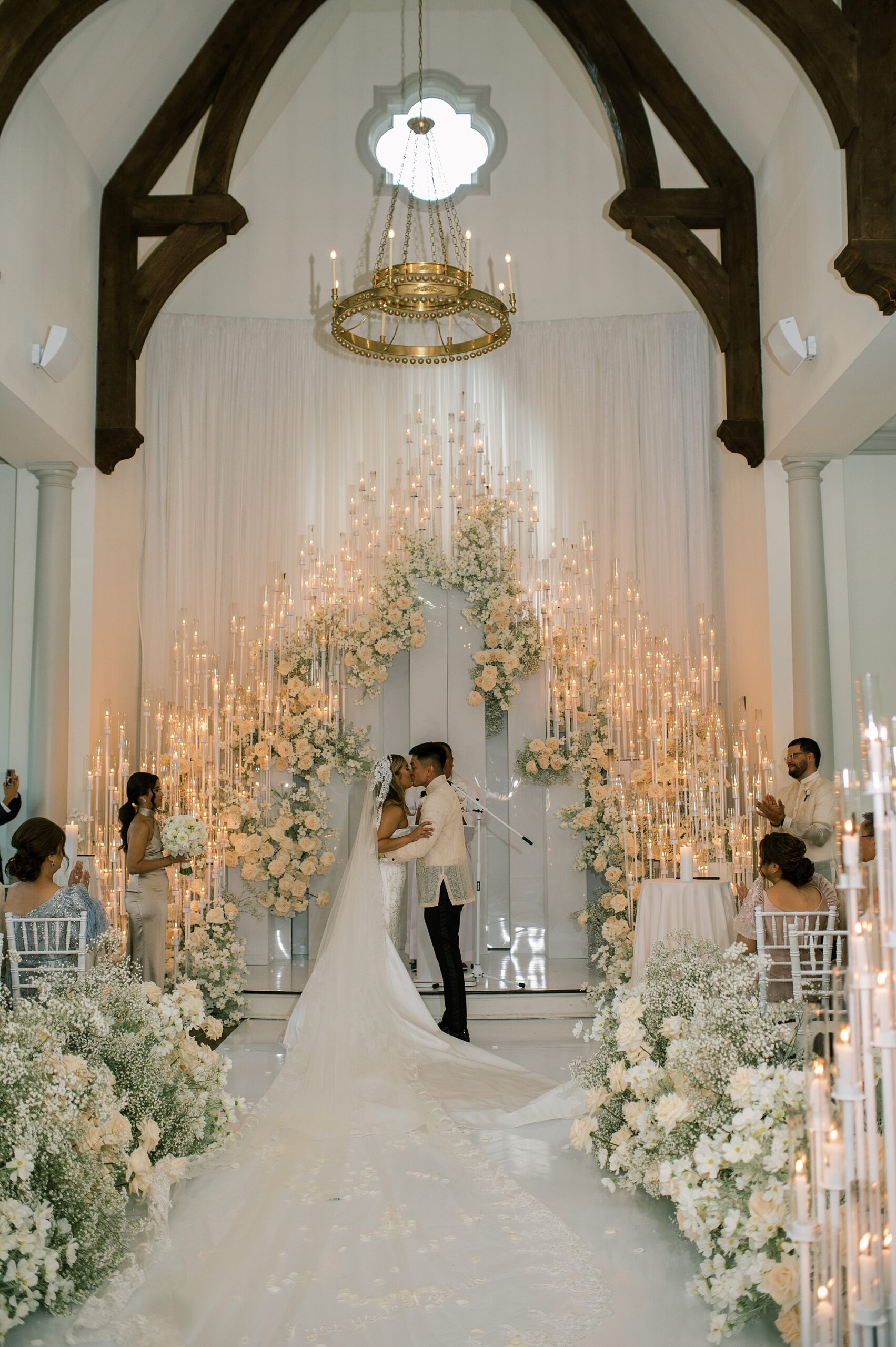 newlyweds kiss during ceremony inside Park Chateau Estate chapel 