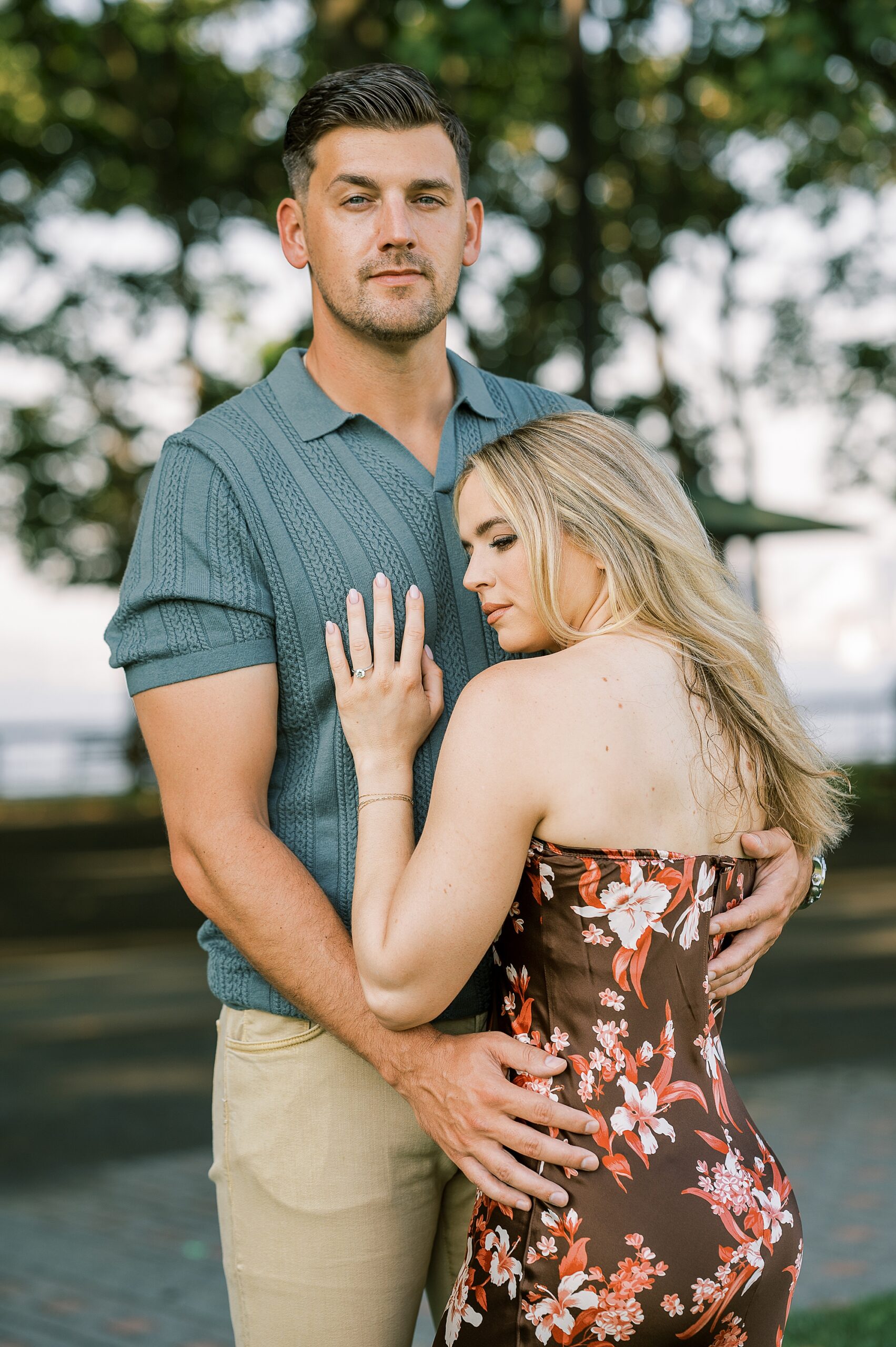 engaged couple hugs while woman leans into man's chest during Hoboken NJ engagement session