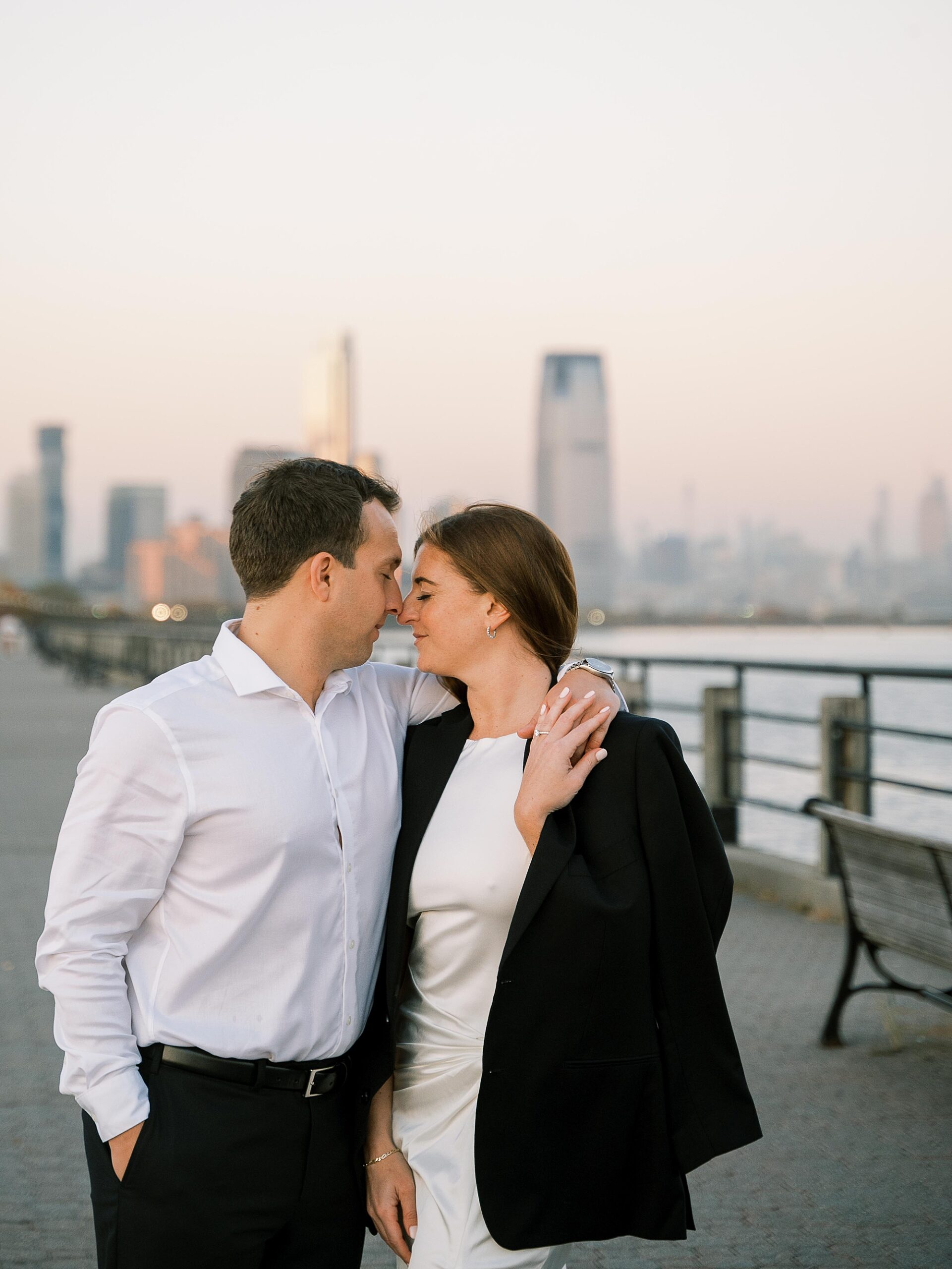 engaged couple hugs leaning heads together and nuzzling noses