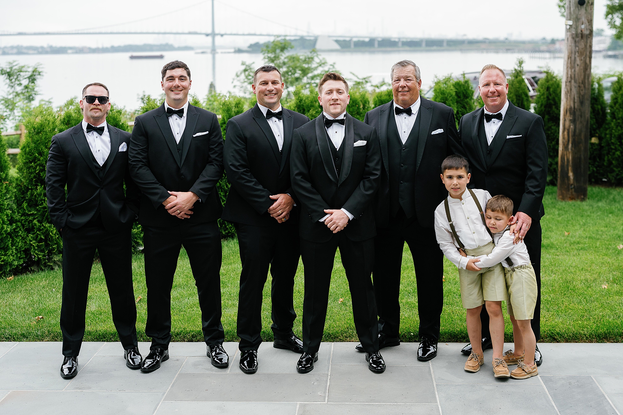 groom stands with groomsmen in classic black suits