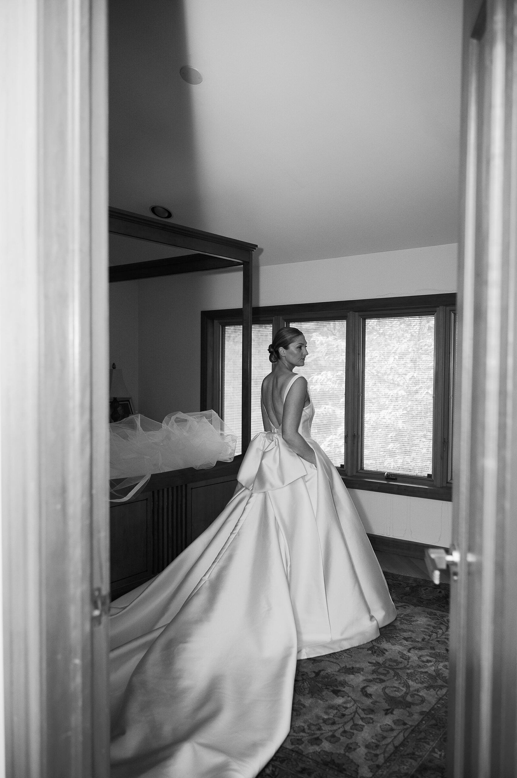 bride walks through room in family home in wedding gown