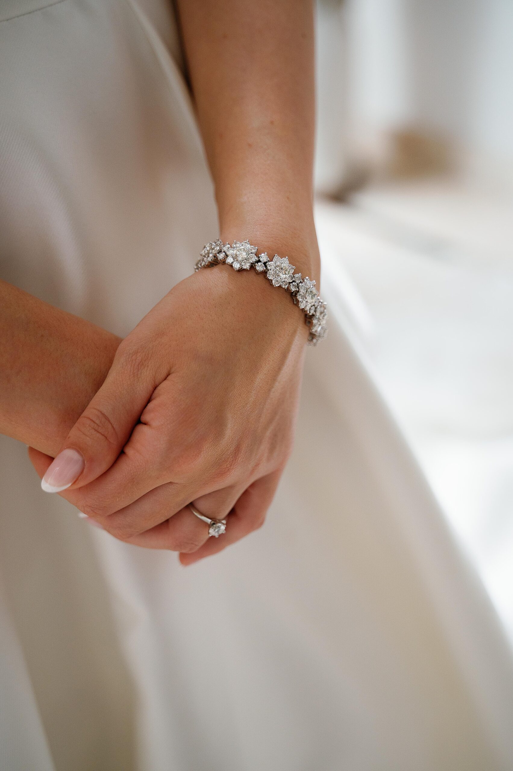 bride holds hands together with diamond ring in front