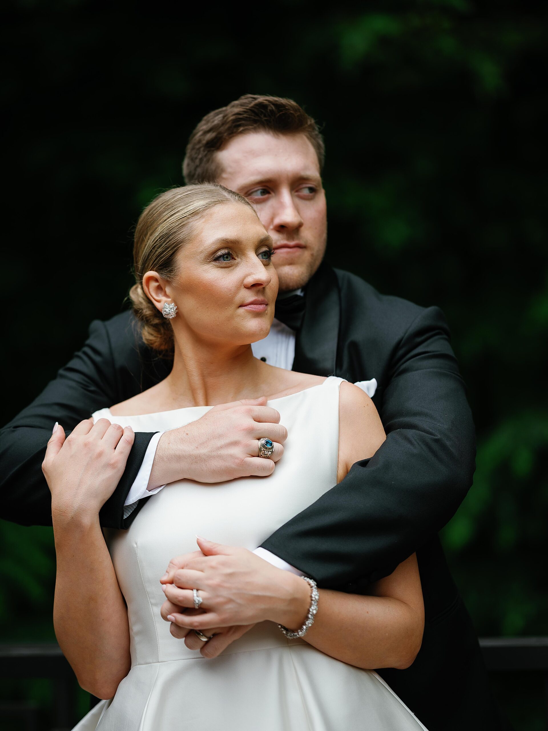 groom hugs bride from behind during wedding portraits