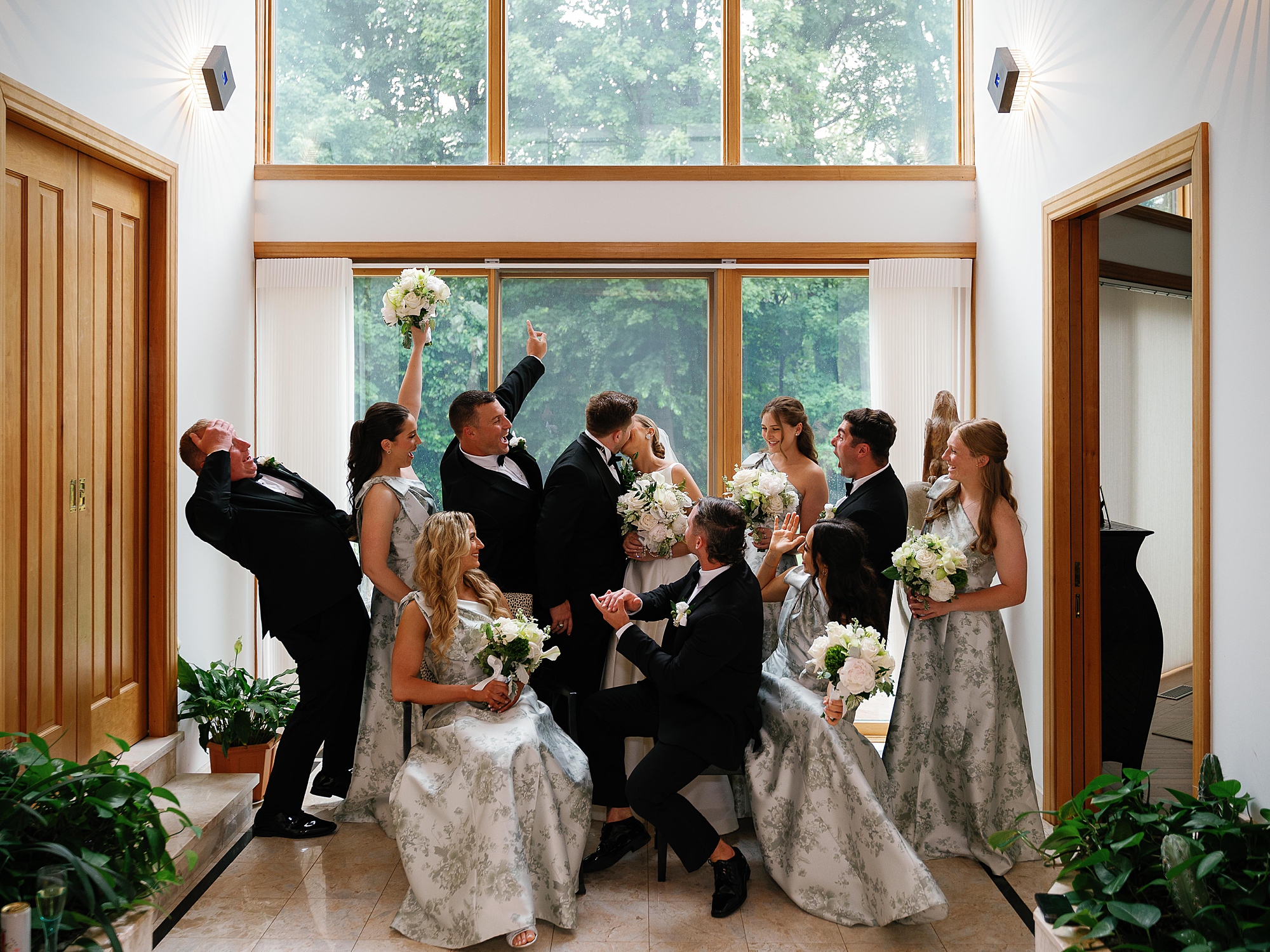 newlyweds cheer with wedding party around them at Bronxville Field Club