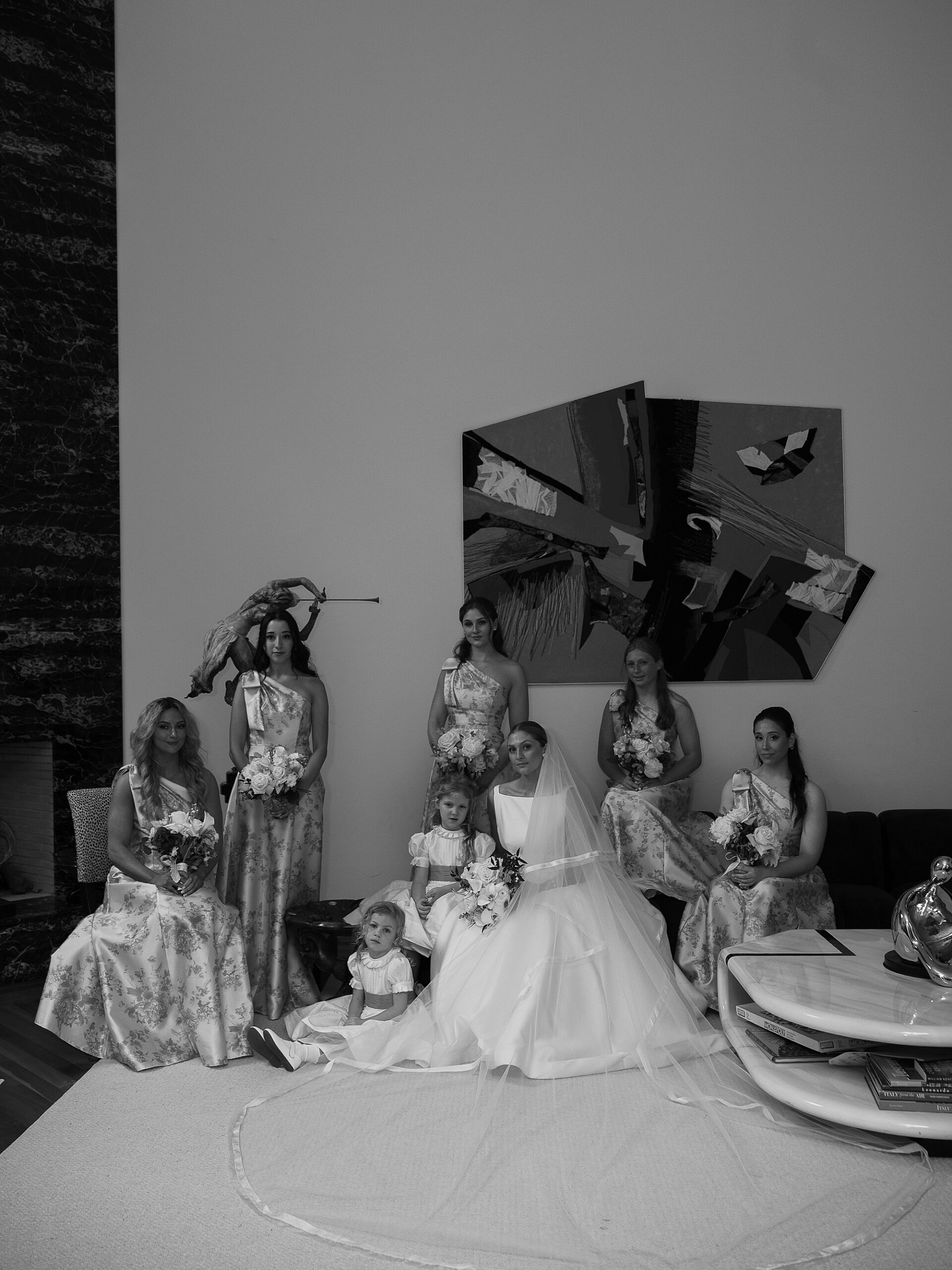 bride sits with bridesmaids around her under artwork at the Bronxville Field Club