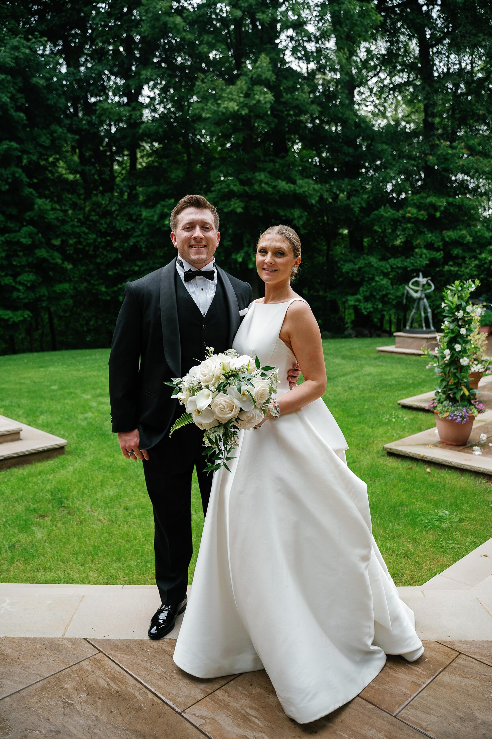 bride and groom smile on lawn at the Bronxville Field Club