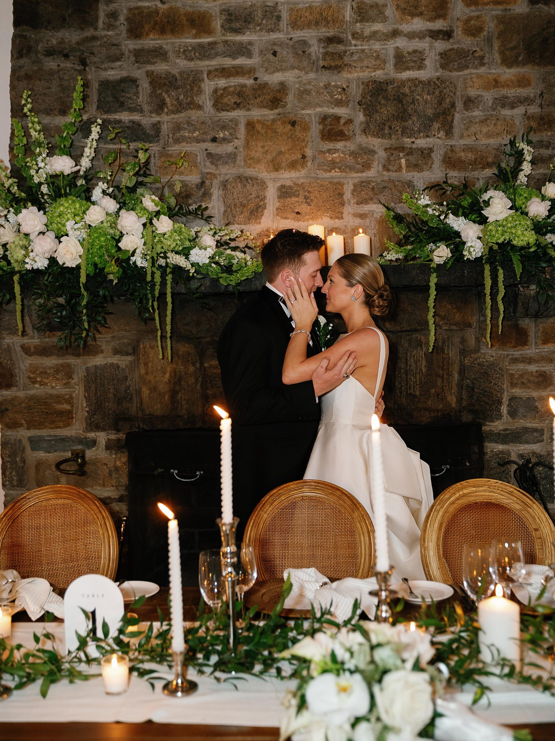 bride and groom lean heads together behind table during reception at the Bronxville Field Club